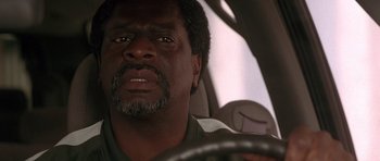 Movie still from “Runaway Jury” (2003), directed by Gary Fleder – A person driving a car; Close Up shot, Low angle