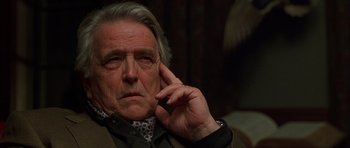 Movie still from “Runaway Jury” (2003), directed by Gary Fleder – An older man is sitting with his hand to his ear; Close Up shot, Over the shoulder angle