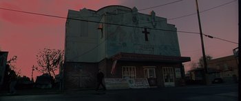 Movie still from “Runaway Jury” (2003), directed by Gary Fleder – A person walking in front of a building with a cross on it; Extreme Wide shot, Low angle