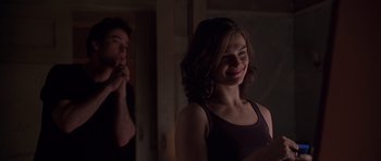 Movie still from “Runaway Jury” (2003), directed by Gary Fleder – A young woman smiles in front of a mirror; Medium shot, Over the shoulder angle