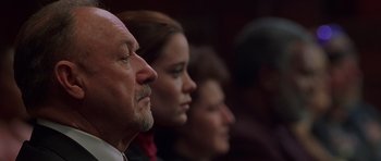 Movie still from “Runaway Jury” (2003), directed by Gary Fleder – A man and two women sitting next to each other; Close Up shot, Low angle