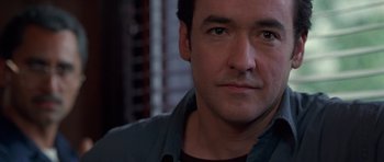 Movie still from “Runaway Jury” (2003), directed by Gary Fleder – A man's face in a dark room; Close Up shot, Low angle