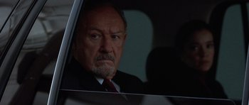 Movie still from “Runaway Jury” (2003), directed by Gary Fleder – An older man wearing a suit and red tie looking out of a car window; Close Up shot, Low angle