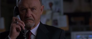 Movie still from “Runaway Jury” (2003), directed by Gary Fleder – An older man wearing a suit and a red neck tie; Close Up shot, Low angle
