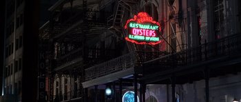 Movie still from “Runaway Jury” (2003), directed by Gary Fleder – A neon restaurant sign is lit up at night; Extreme Wide shot, Low angle