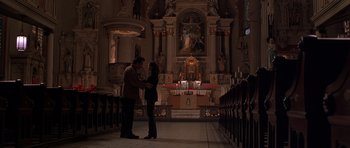 Movie still from “Runaway Jury” (2003), directed by Gary Fleder – A man and a woman standing in front of an altar; Wide shot, Low angle
