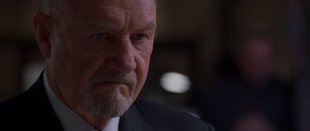 Movie still from “Runaway Jury” (2003), directed by Gary Fleder – An older man in a business suit stares into the camera; Close Up shot, Low angle