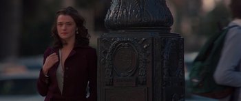 Movie still from “Runaway Jury” (2003), directed by Gary Fleder – A woman standing in front of an ornate metal post; Medium shot, Over the shoulder angle