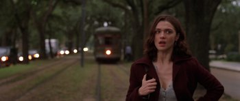 Movie still from “Runaway Jury” (2003), directed by Gary Fleder – A woman walking down a train track next to trees; Medium shot, Over the shoulder angle