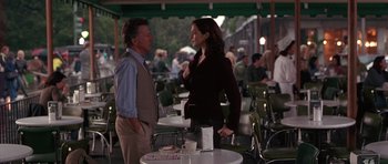 Movie still from “Runaway Jury” (2003), directed by Gary Fleder – A man and a woman standing next to each other at an outdoor cafe; Medium shot, Over the shoulder angle
