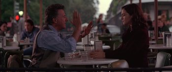 Movie still from “Runaway Jury” (2003), directed by Gary Fleder – Two people sitting at an outdoor table talking to each other; Medium shot, Over the shoulder angle