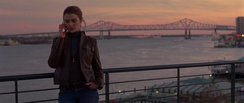 Movie still from “Runaway Jury” (2003), directed by Gary Fleder – A woman standing next to a railing near a body of water; Medium shot, Over the shoulder angle