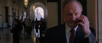 Movie still from “Runaway Jury” (2003), directed by Gary Fleder – A man in a suit and tie in a hallway; Close Up shot, Low angle