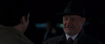 Movie still from “Runaway Jury” (2003), directed by Gary Fleder – An older man wearing a black hat and a black suit; Close Up shot, Over the shoulder angle