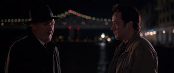 Movie still from “Runaway Jury” (2003), directed by Gary Fleder – Two men standing next to each other near a body of water at night; Close Up shot, Over the shoulder angle