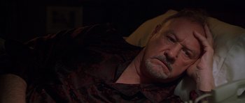 Movie still from “Runaway Jury” (2003), directed by Gary Fleder – An older man laying in a bed with his eyes closed; Close Up shot, Over the shoulder angle