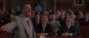 Movie still from “Runaway Jury” (2003), directed by Gary Fleder – A group of people sitting in front of a microphone; Medium shot, Over the shoulder angle