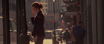 Movie still from “Runaway Jury” (2003), directed by Gary Fleder – A woman standing on the side of the street talking on a cell phone; Medium shot, Over the shoulder angle