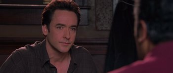 Movie still from “Runaway Jury” (2003), directed by Gary Fleder – A person sitting in front of a wall; Close Up shot, Over the shoulder angle