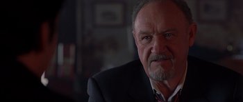 Movie still from “Runaway Jury” (2003), directed by Gary Fleder – An older man in a black suit and a red neck tie; Close Up shot, Low angle