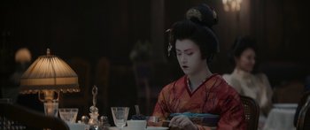 Movie still from “1899” (2022), created by Jantje Friese – A geisha sitting at a table in front of a plate of food; Close Up shot, Over the shoulder angle