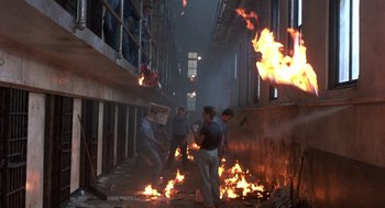 Movie still from “Runaway Train” (1985), directed by Andrey Konchalovskiy – A group of people in an alley with fire; Wide shot, High angle