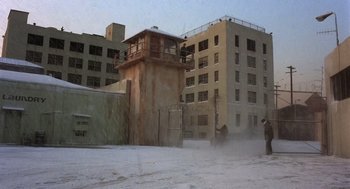 Movie still from “Runaway Train” (1985), directed by Andrey Konchalovskiy – Two men are standing in the middle of a snow covered street; Extreme Wide shot, High angle