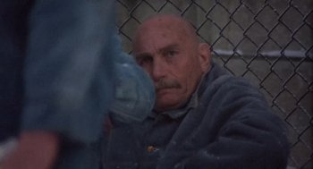 Movie still from “Runaway Train” (1985), directed by Andrey Konchalovskiy – An old man with a bald head looking at the camera; Close Up shot, High angle
