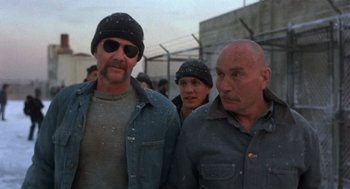 Movie still from “Runaway Train” (1985), directed by Andrey Konchalovskiy – A group of men standing next to each other; Medium shot, Low angle