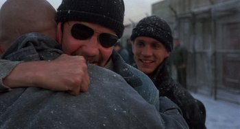 Movie still from “Runaway Train” (1985), directed by Andrey Konchalovskiy – Two men in winter clothes and hats are hugging; Close Up shot, Over the shoulder angle