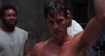 Movie still from “Runaway Train” (1985), directed by Andrey Konchalovskiy – A man with a wet shirt on looking at the camera; Close Up shot, Low angle