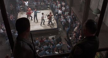 Movie still from “Runaway Train” (1985), directed by Andrey Konchalovskiy – A crowd of people watching two men in a boxing ring; Extreme Wide shot, High angle