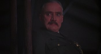 Movie still from “Runaway Train” (1985), directed by Andrey Konchalovskiy – A man with a mustache wearing a police uniform; Close Up shot, Low angle