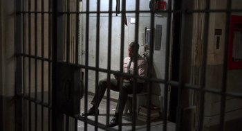 Movie still from “Runaway Train” (1985), directed by Andrey Konchalovskiy – A man sitting in a chair in a jail cell; Wide shot, High angle