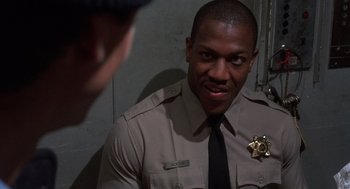 Movie still from “Runaway Train” (1985), directed by Andrey Konchalovskiy – A man in a police uniform talking to another man; Close Up shot, Low angle