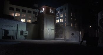 Movie still from “Runaway Train” (1985), directed by Andrey Konchalovskiy – A building that has a tower in the middle of it at night; Extreme Wide shot, High angle