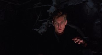 Movie still from “Runaway Train” (1985), directed by Andrey Konchalovskiy – A man in a black shirt is in the dark; Close Up shot, Low angle