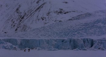 Movie still from “Runaway Train” (1985), directed by Andrey Konchalovskiy – Two people are skiing on a snowy mountain; Extreme Wide shot, High angle