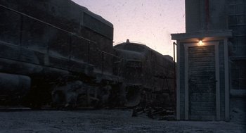 Movie still from “Runaway Train” (1985), directed by Andrey Konchalovskiy – A train is parked on the side of the road; Extreme Wide shot, Low angle