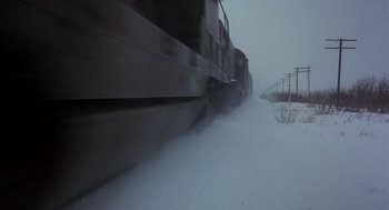 Movie still from “Runaway Train” (1985), directed by Andrey Konchalovskiy – A train traveling down train tracks in the snow; Extreme Wide shot, Low angle