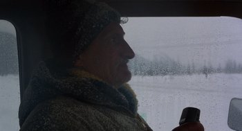 Movie still from “Runaway Train” (1985), directed by Andrey Konchalovskiy – A man in a winter coat looking out of a window; Close Up shot, Low angle