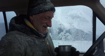 Movie still from “Runaway Train” (1985), directed by Andrey Konchalovskiy – An older man holding a cup of hot chocolate; Close Up shot, Low angle