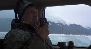 Movie still from “Runaway Train” (1985), directed by Andrey Konchalovskiy – An older man holding a phone in a car; Medium shot, Low angle