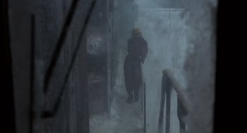 Movie still from “Runaway Train” (1985), directed by Andrey Konchalovskiy – A man in a red jacket standing in the fog; Wide shot, High angle