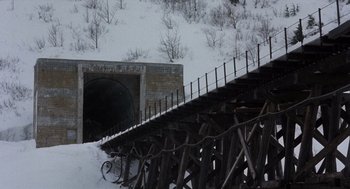 Movie still from “Runaway Train” (1985), directed by Andrey Konchalovskiy – A train bridge over a snow covered river; Extreme Wide shot, High angle