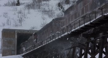 Movie still from “Runaway Train” (1985), directed by Andrey Konchalovskiy – A train traveling over a bridge on a snowy day; Extreme Wide shot, High angle