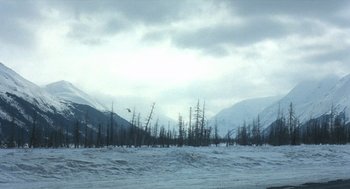 Movie still from “Runaway Train” (1985), directed by Andrey Konchalovskiy – A view of a snowy mountain range with trees in the background; Extreme Wide shot, Low angle