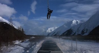 Movie still from “Runaway Train” (1985), directed by Andrey Konchalovskiy – A man flying through the air while riding a snowboard; Wide shot, Low angle