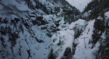 Movie still from “Runaway Train” (1985), directed by Andrey Konchalovskiy – A view from a helicopter of a snowy mountainous area; Extreme Wide shot, High angle