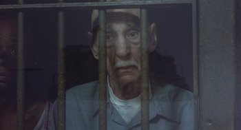 Movie still from “Runaway Train” (1985), directed by Andrey Konchalovskiy – An old man in a jail cell behind bars; Close Up shot, High angle